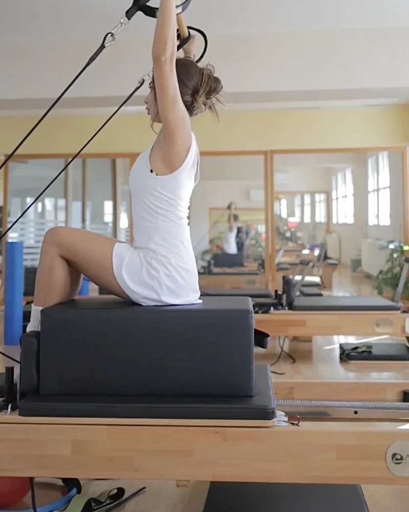 Ενήλικη ασκείται σε Reformer Pilates στο Βικέντια με έλεγχο και σταθερότητα