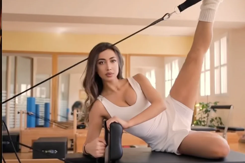 Ασκούμενη σε πλάγια άσκηση ελέγχου στο Pilates Reformer με στήριξη ελατηρίου